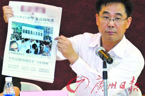 中国医师协会维权委员会委员邓利强拿着媒体头版报道
